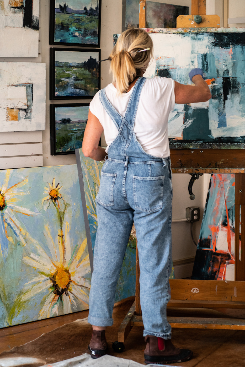 Kim Gibbs standing and painting with her back to the camera