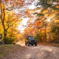 jeep driving through pisgah national forest in the fall