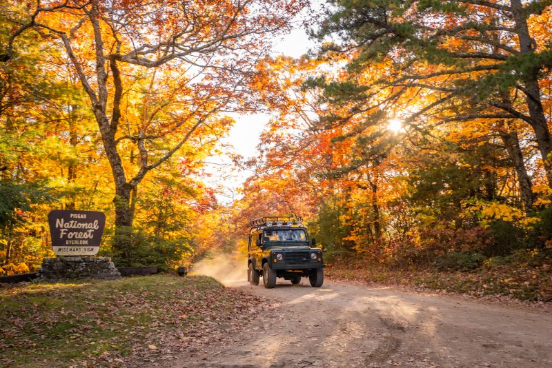 jeep driving through pisgah national forest in the fall