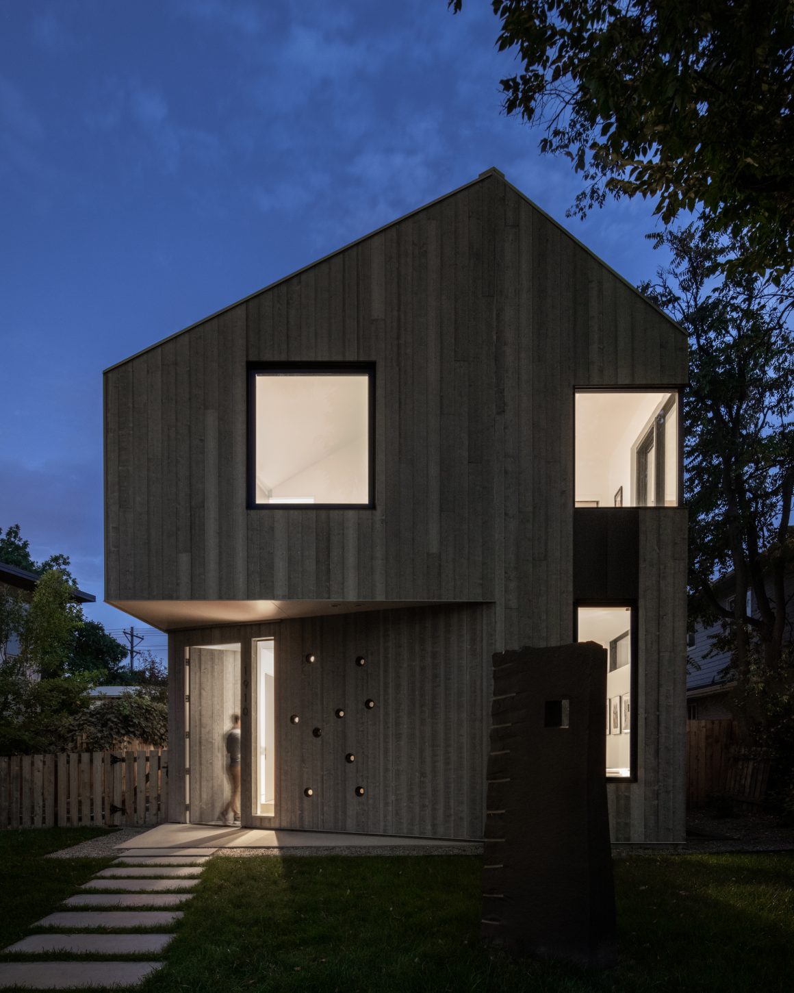 exterior shot of home by arch11 lit at dusk